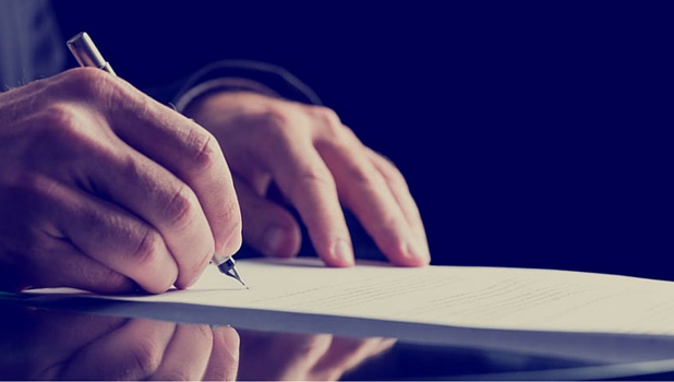 Male writing on paper