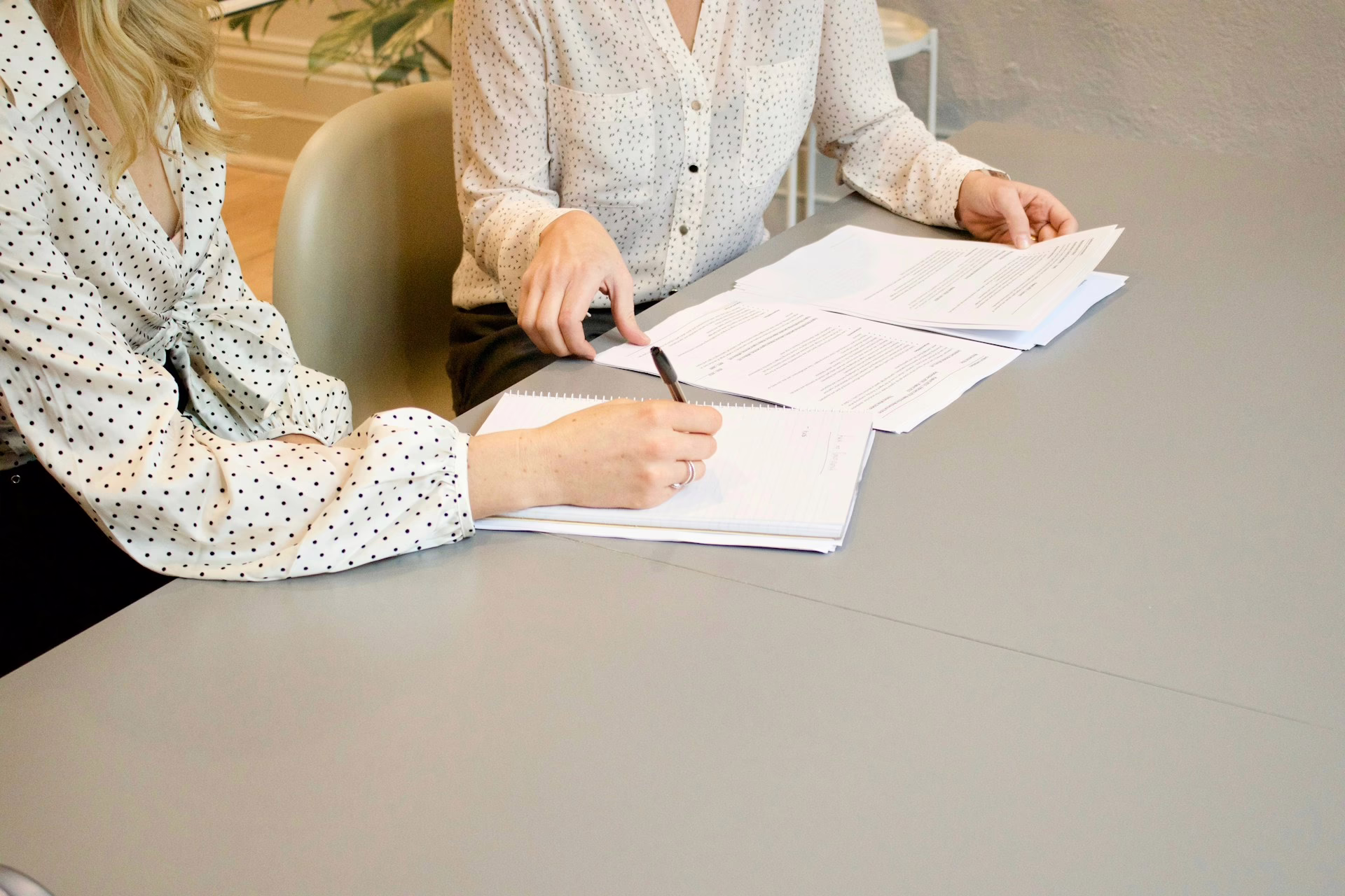 Two professionals reviewing employment documents at a desk