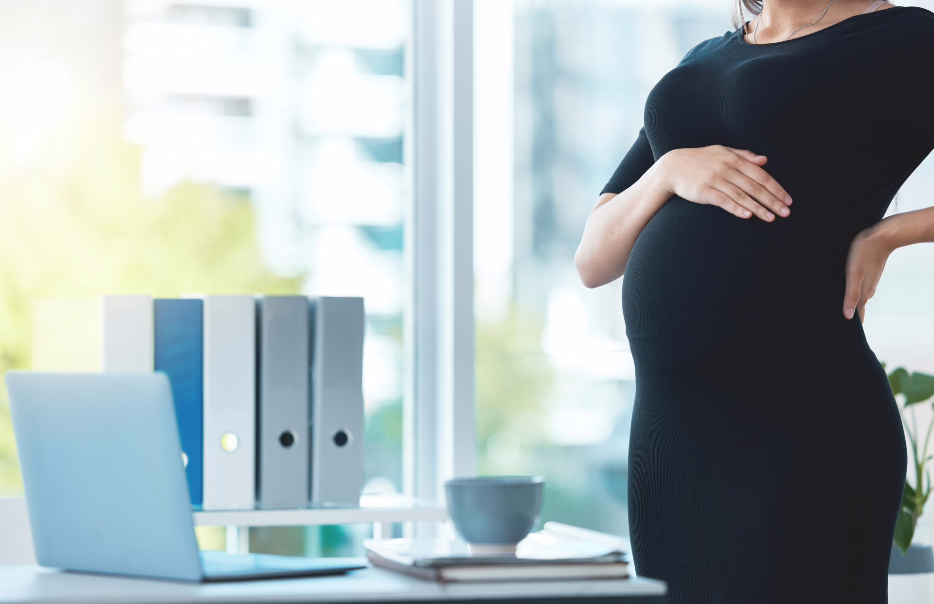 Pregnant woman standing in a professional office environment