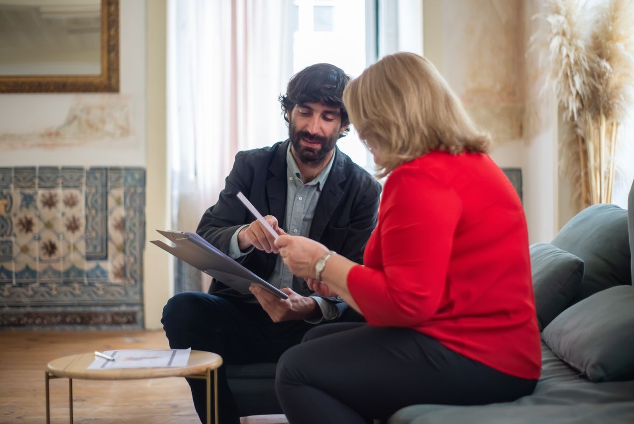 A solicitor and client reviewing a will document together in a home office setting, discussing the details with focus and clarity